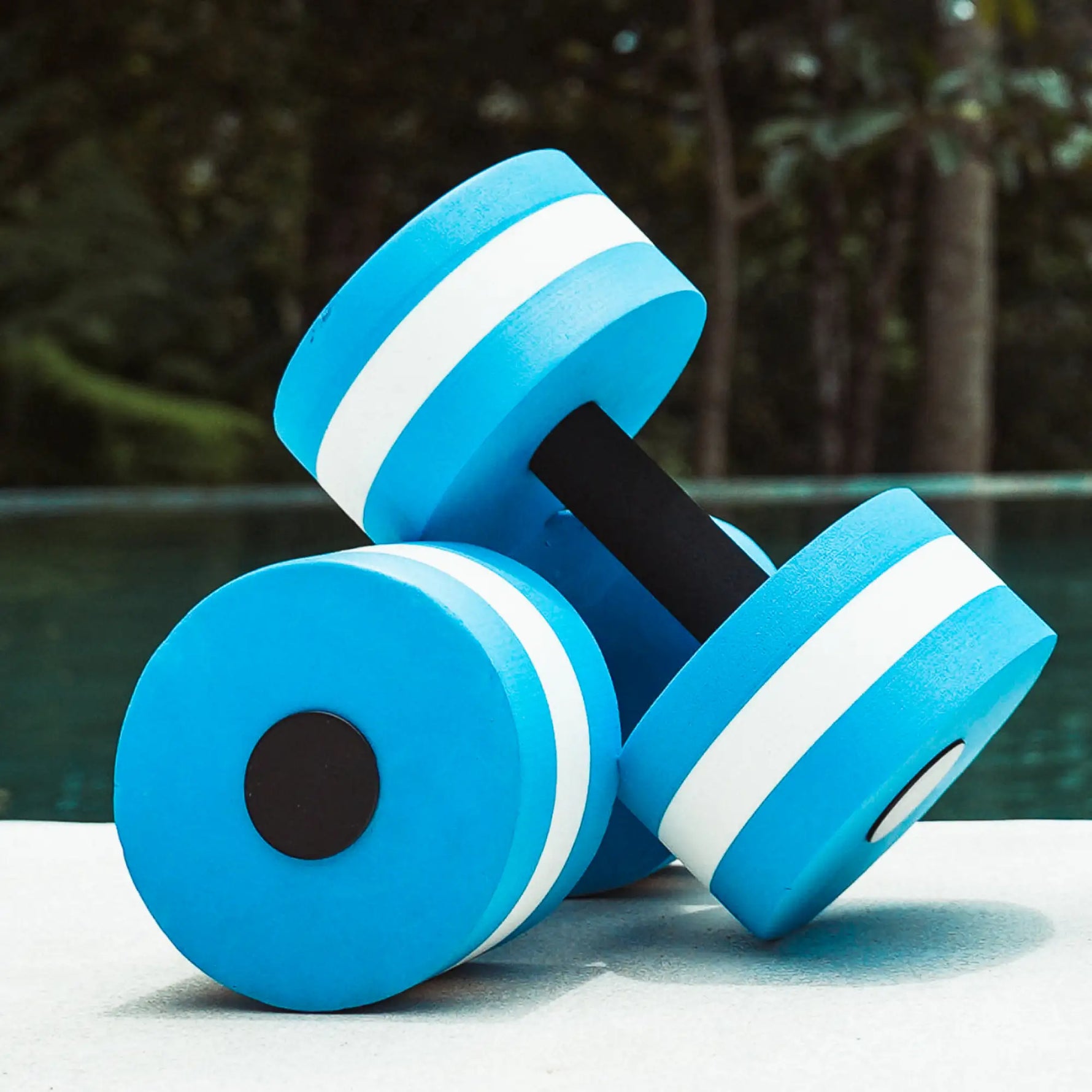 Pair of foam aquatic dumbbells for muscle strengthening.